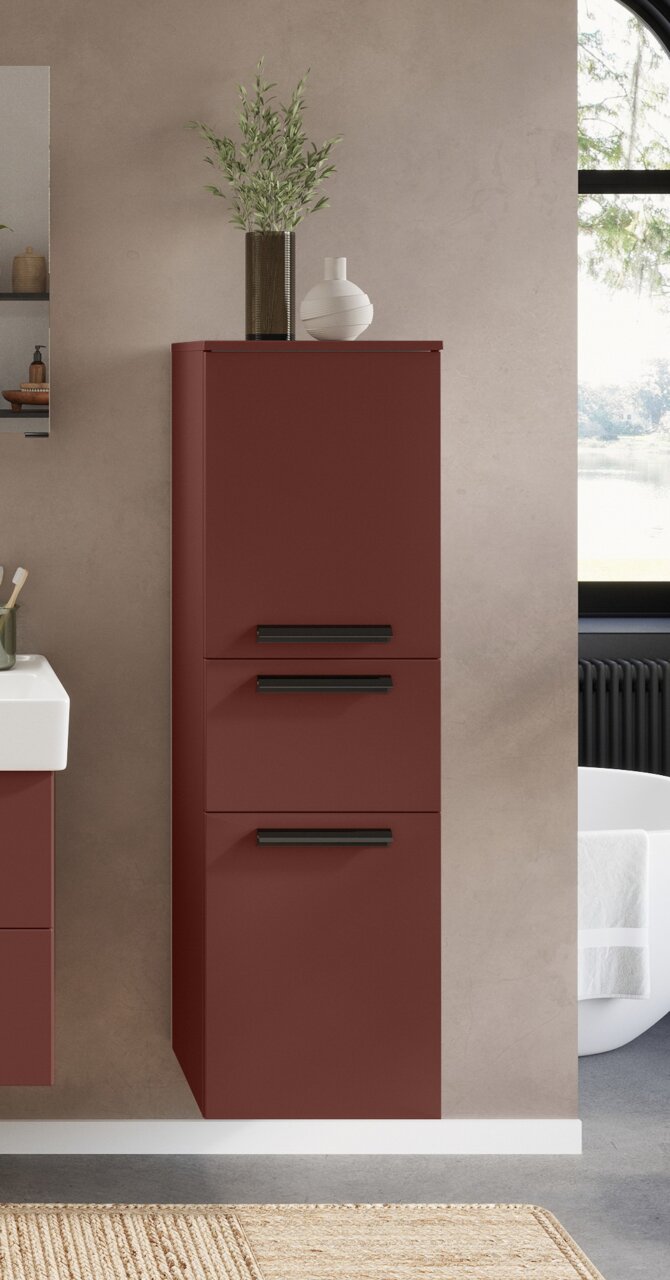 Moderne middenkast in rood met drie zwarte handgrepen, afgebeeld van voren, versierd met planten en een vaas.