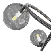 Nahaufnahme einer modernen Pendelleuchte mit zwei rauchgrauen Glaskugeln und geschwungenem Metallrahmen, seitliche Perspektive.