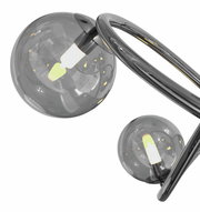 Nahaufnahme einer modernen Pendelleuchte mit zwei rauchgrauen Glaskugeln und geschwungenem Metallrahmen, seitliche Perspektive.