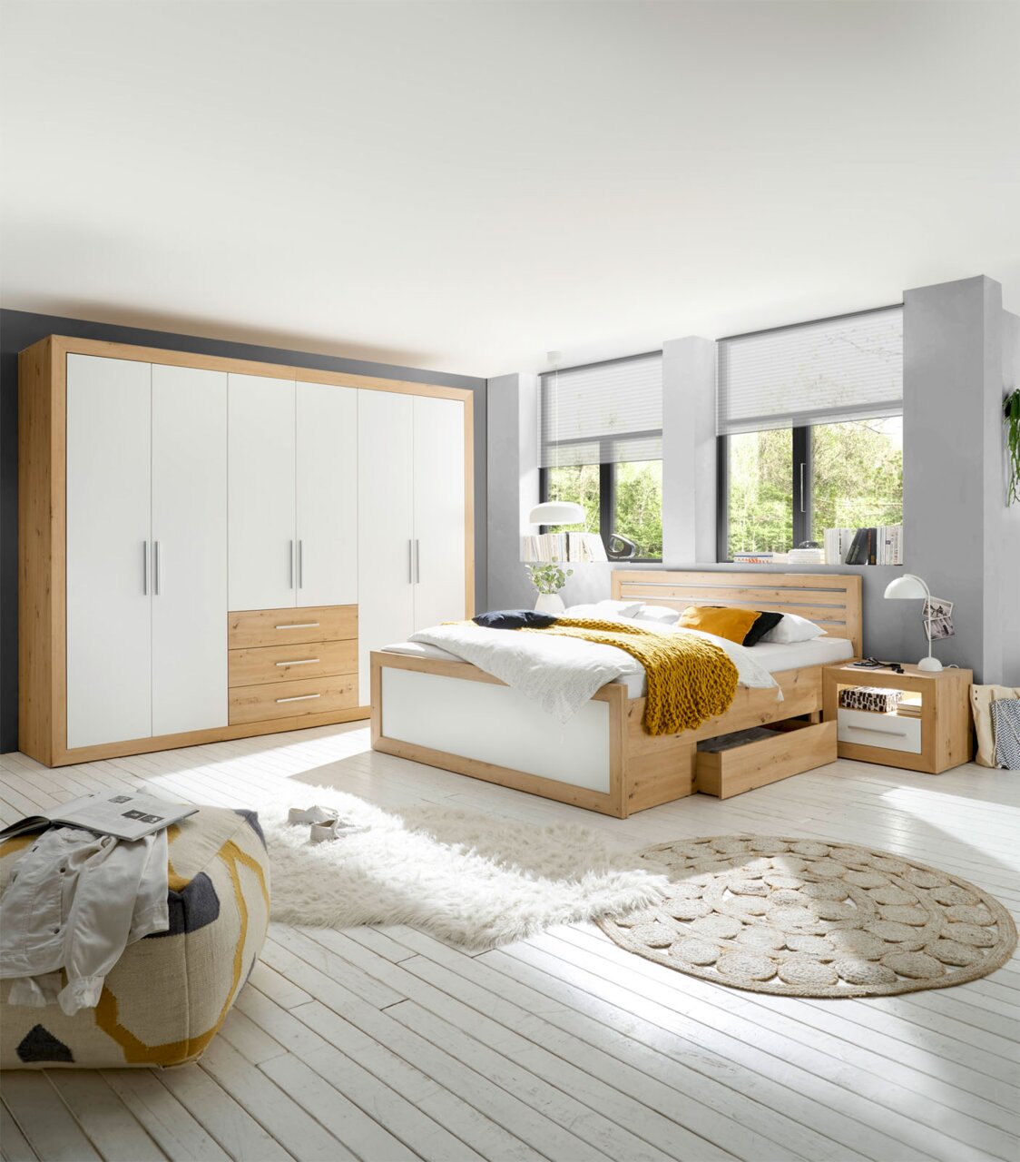 Moderne Schlafzimmermöbel mit einem sechstürigen Drehtürenschrank und einer Bettanlage in Holzoptik, seitliche Perspektive.