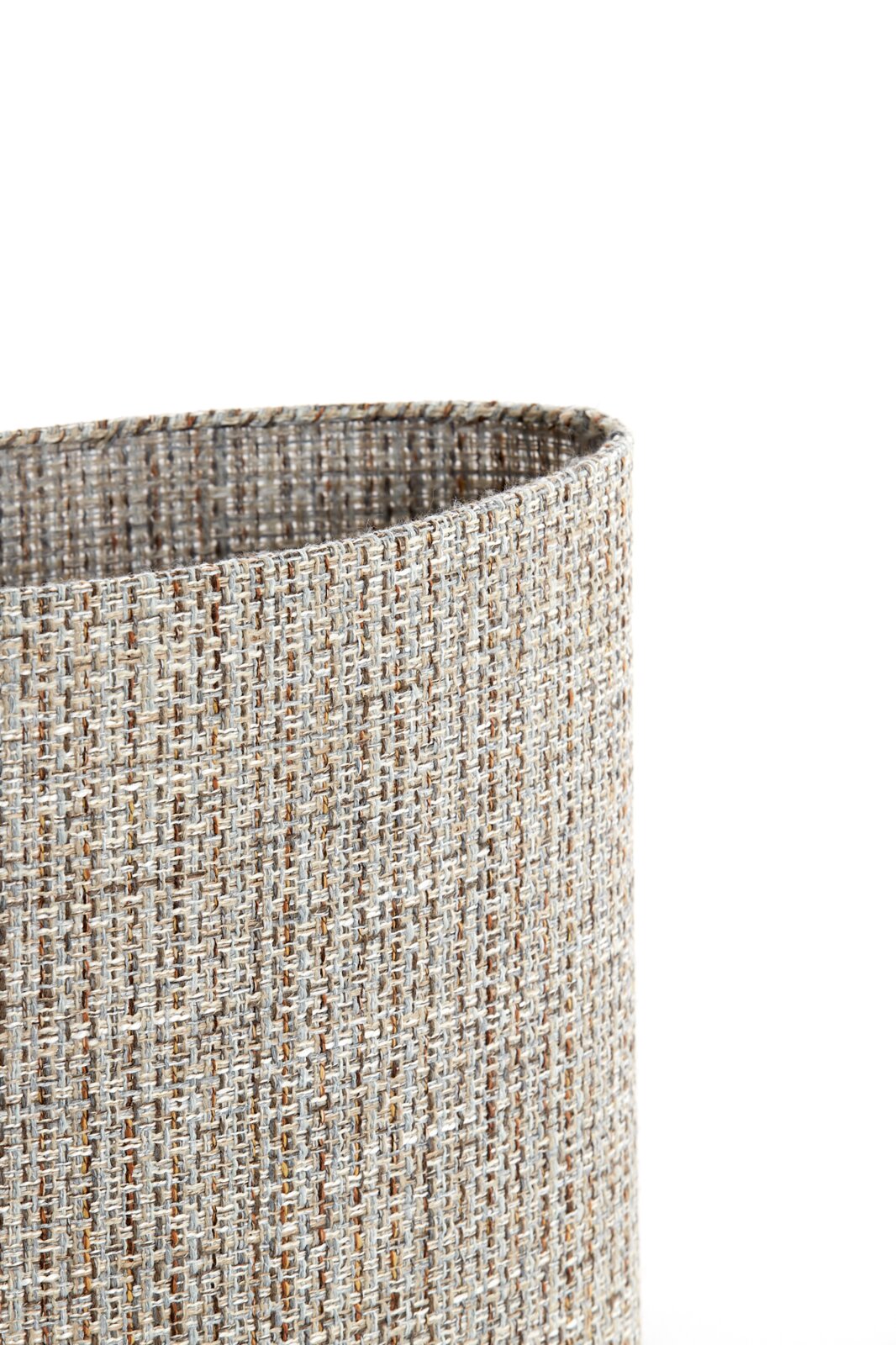 Close-up vanuit schuin bovenaanzicht van een cilindervormige lampenkap met grof geweven textiel in beige, grijs en bruin op een witte achtergrond