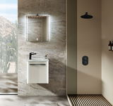 Modernes Gästebad mit Wandspiegel, Waschbecken mit schwarzer Armatur und Dusche, seitliche Perspektive.