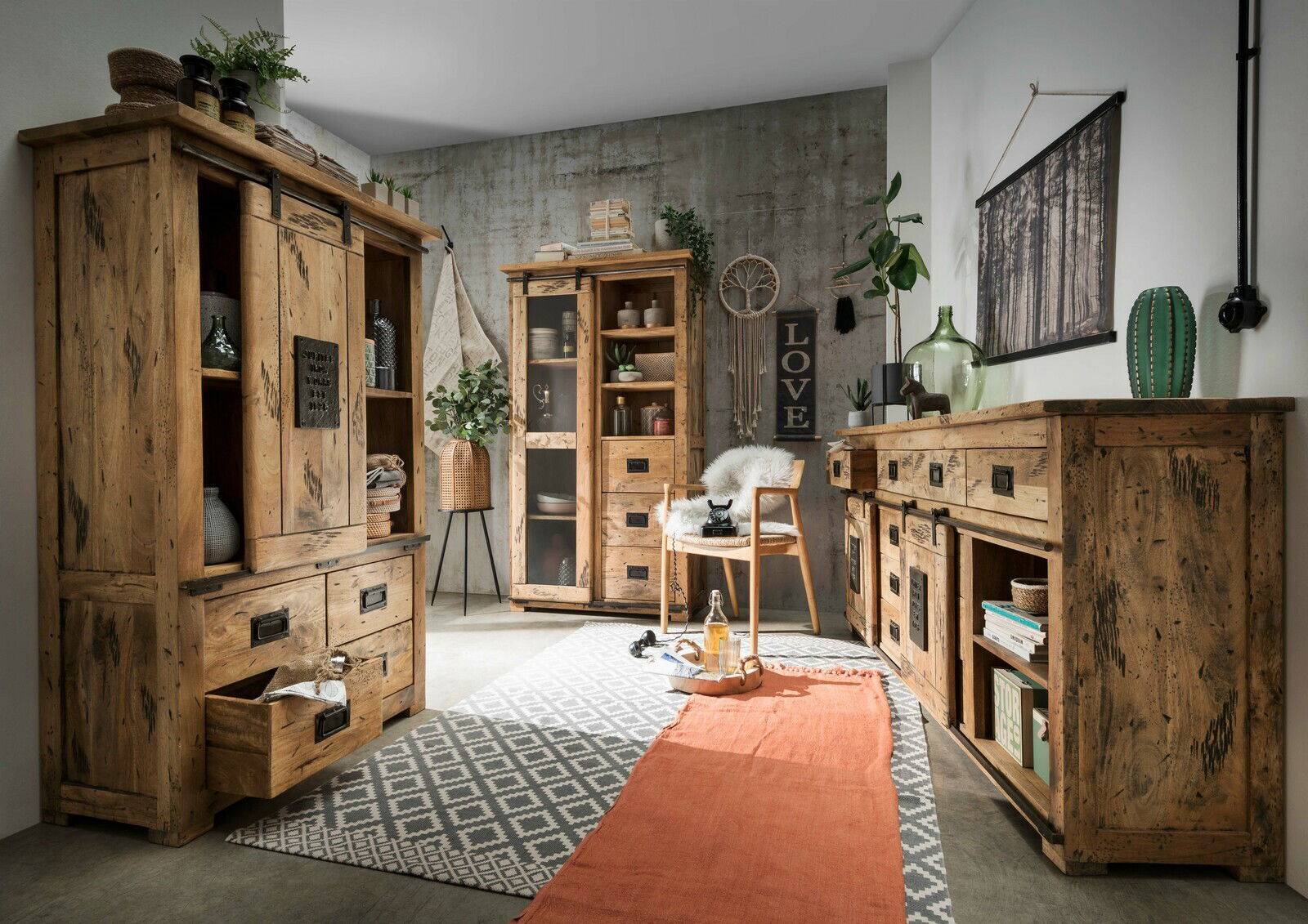 Rustikales Wohnzimmer mit Holzmöbeln, darunter eine Vitrine und ein Sideboard, aus der Perspektive von vorne rechts betrachtet.