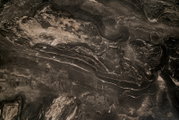 Dunkle Marmoroberfläche mit markanter schwarz-grauer Maserung und hellen Adern in frontaler Detailansicht von oben