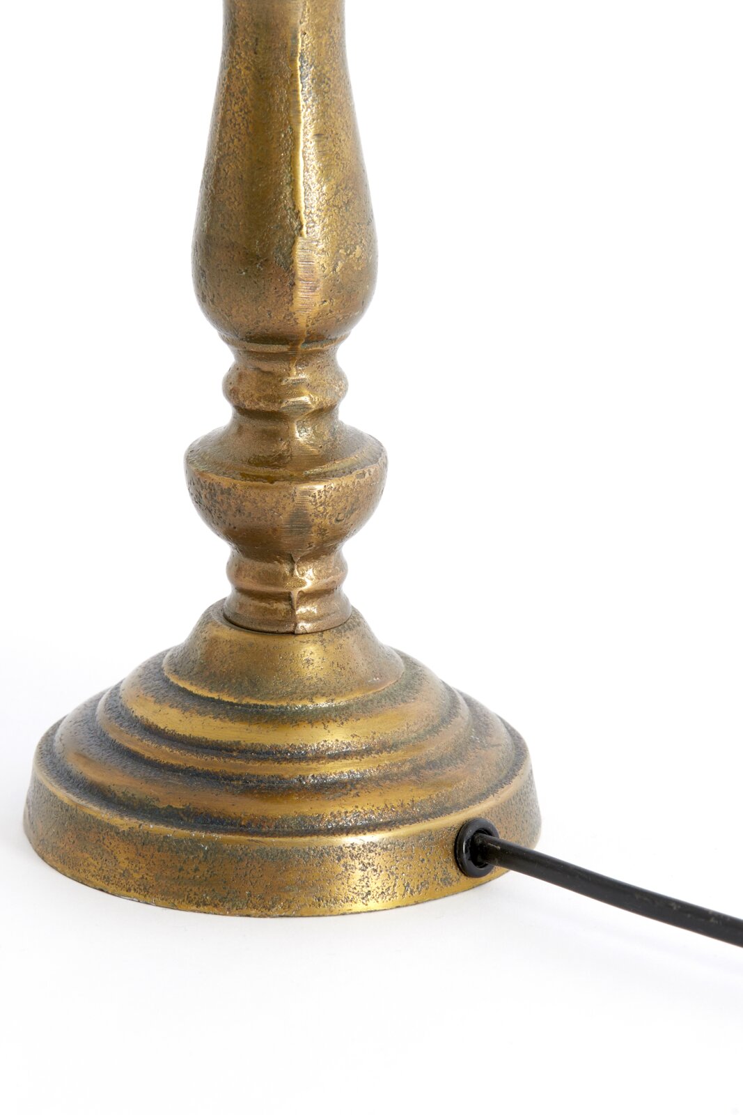 Nahaufnahme eines antik aussehenden, goldfarbenen Lampenfußes mit Kabelanschluss, seitliche Perspektive