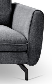 Detailaufnahme eines grauen Stoffsofas mit abgerundeter Armlehne, Sitzkissen und schwarzem Metallfuß, seitliche Perspektive