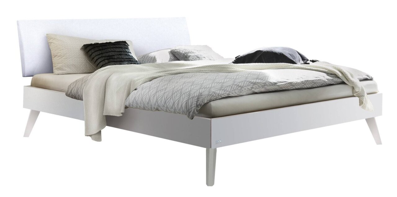 Modernes weißes Bettgestell mit Kopfteil, seitliche Perspektive, dekoriert mit Kissen und Decken.