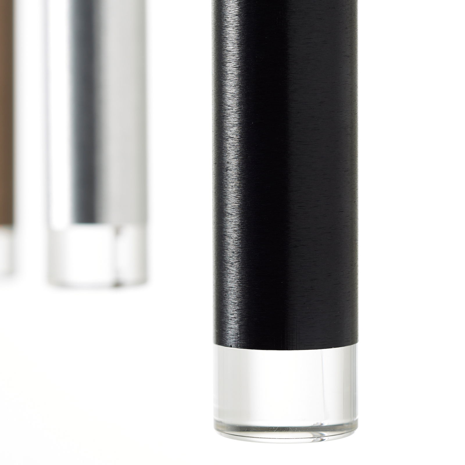 Nahaufnahme von zylindrischen LED-Leuchten in verschiedenen Farben, darunter Schwarz, Silber und Braun, mit einer klaren Basis. Perspektive von unten.