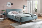 Polsterbett in einem modernen Schlafzimmer, seitliche Perspektive, mit blauer Stoffpolsterung und Holzfüßen, dekoriert mit Kissen und Decken.