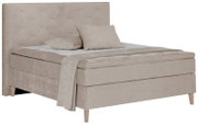 Beiges Boxspringbett mit hohem, gestepptem Kopfteil und zwei Kissen, seitliche Perspektive
