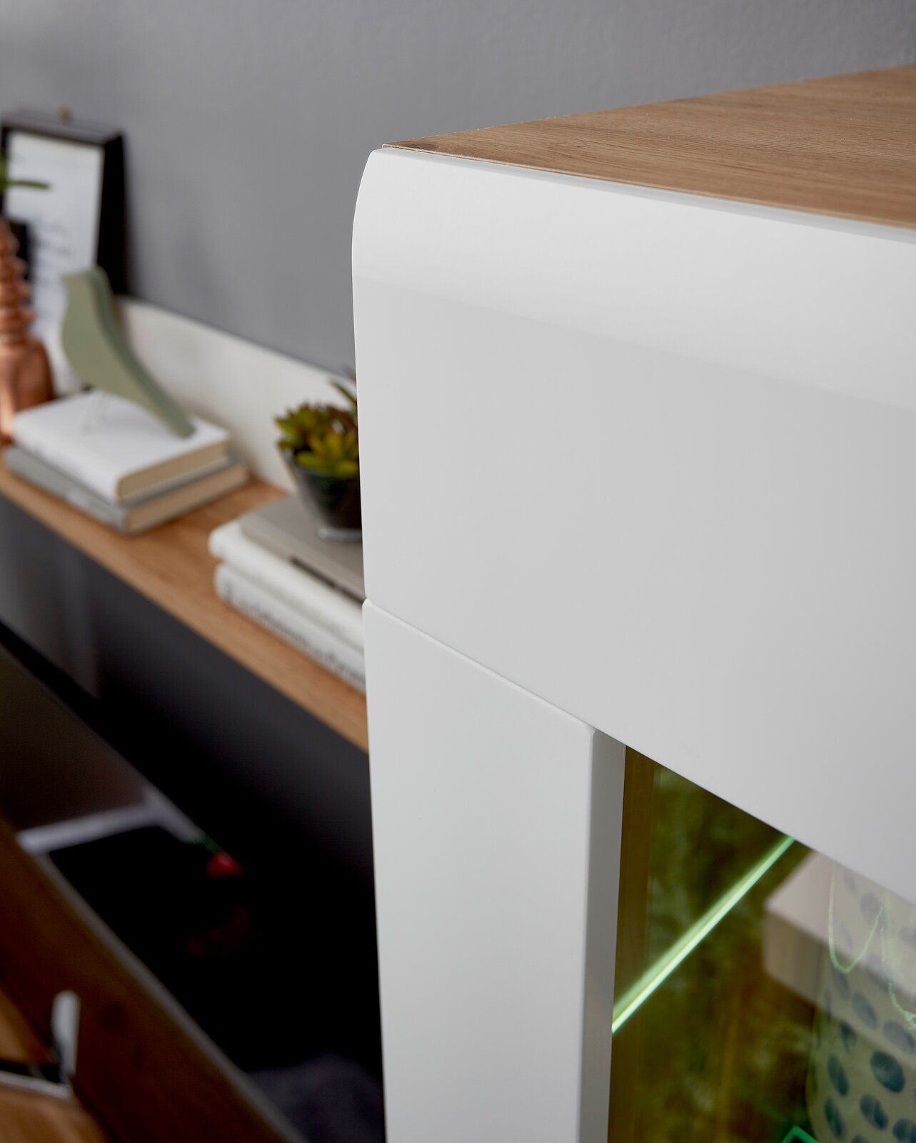 Nahaufnahme einer modernen Wandkombination mit weißem und holzfarbenem Design, seitliche Perspektive.