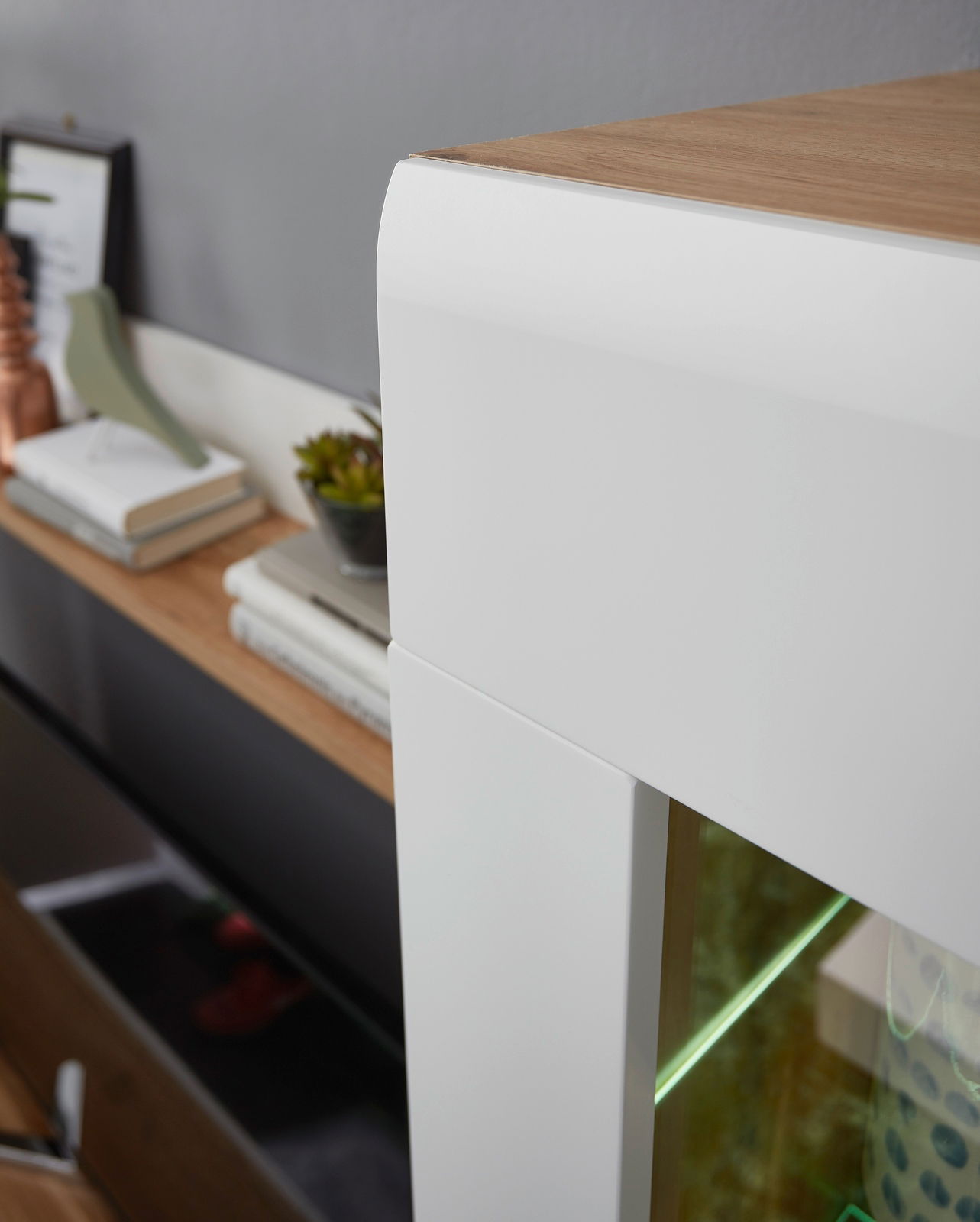 Nahaufnahme einer modernen Wandkombination mit weißem und holzfarbenem Design, seitliche Perspektive.