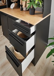 Nahaufnahme eines modernen Buffet-Schranks mit schwarzen Schubladen und einer Holzarbeitsplatte, von oben betrachtet.