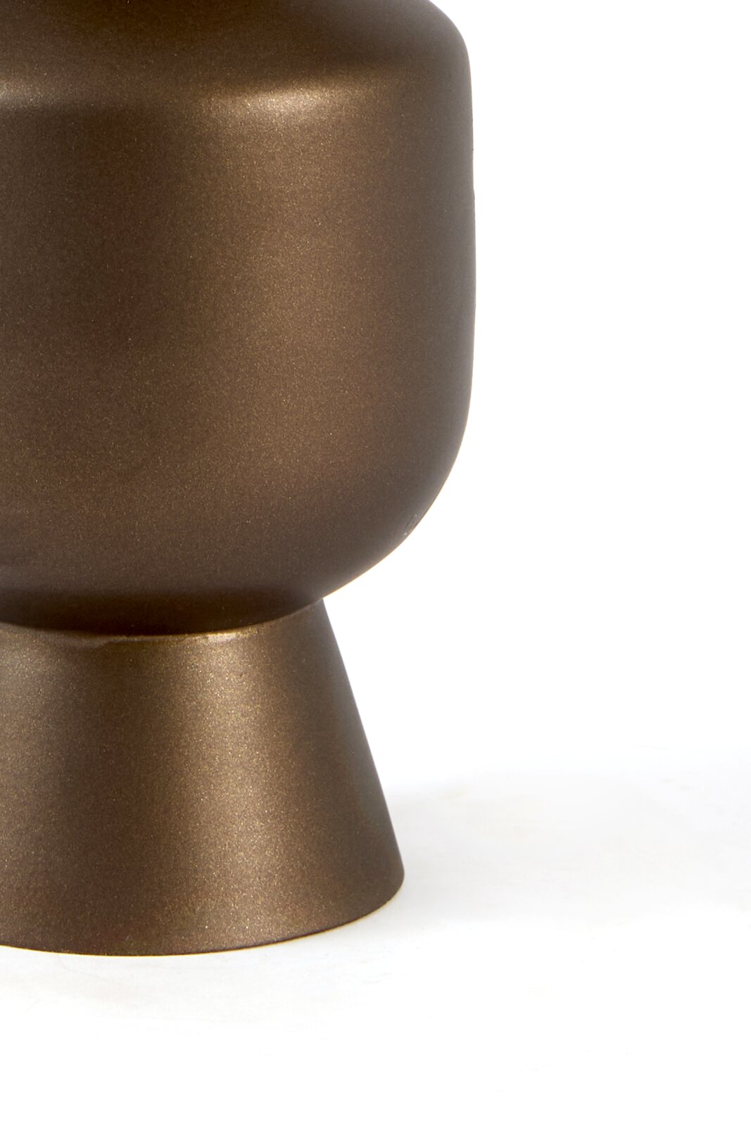 Detailopname vanuit zijaanzicht van een bronskleurig decoratief object met een afgeronde vorm en uitlopende voet tegen een witte achtergrond