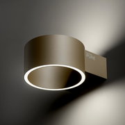 Moderne wandlamp PURE Clipse in zijaanzicht, met een ronde, goudkleurige behuizing en een verlichte led-ring.