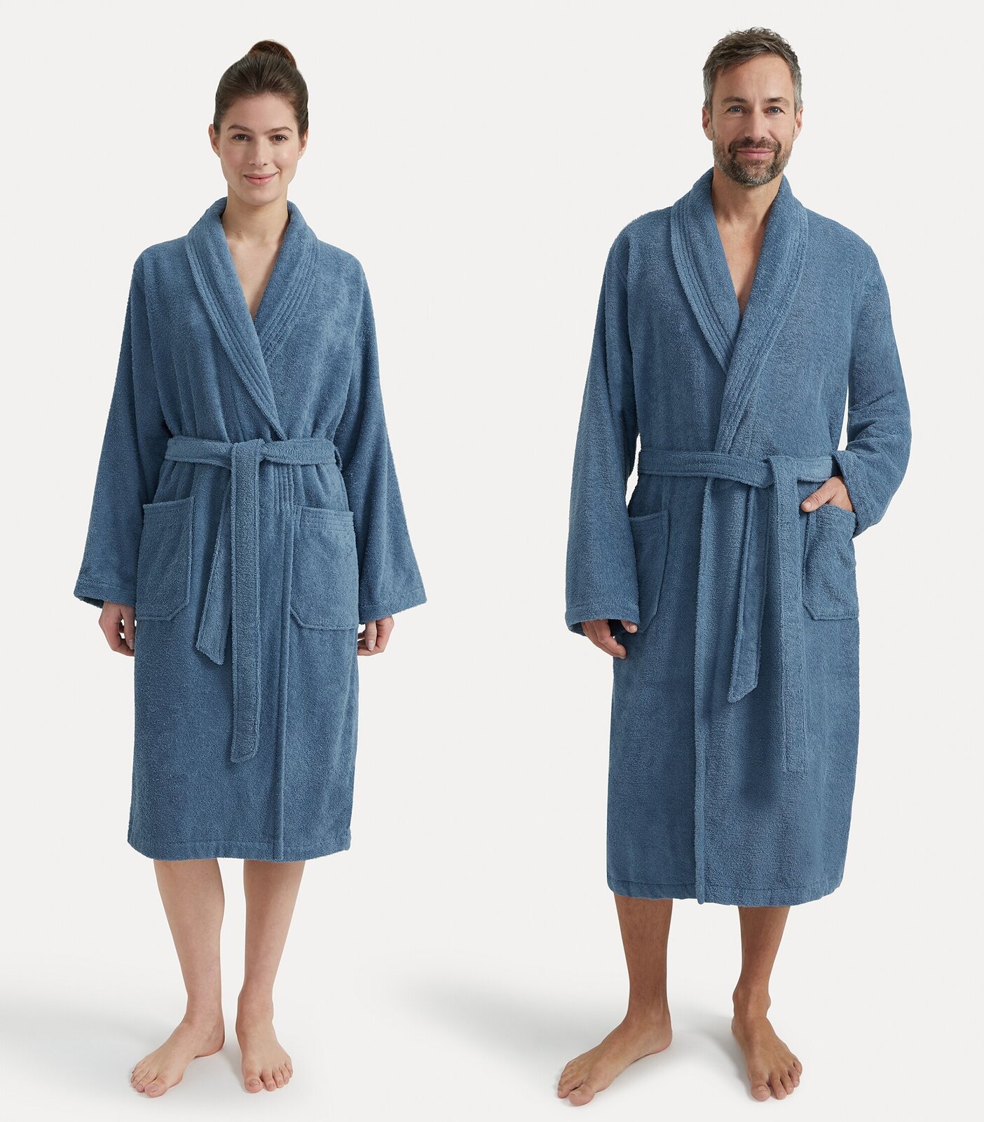 Zwei Personen tragen blaue Bademäntel mit Schalkragen, Vorderansicht.