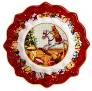 Kerstschaal met rode rand, versierd met cadeautjes en een motief van een hobbelpaard, een teddybeer en een kerstboom, gezien vanuit vogelperspectief.