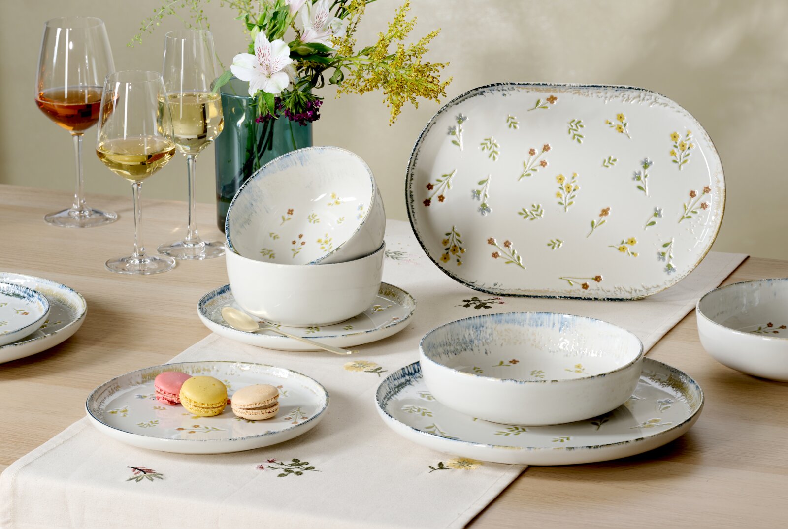 Ritzenhoff & Breker Dessertteller VIOLA Florales Geschirrset aus weißer Keramik mit Tellern, Schalen und großer Servierplatte, dekorativ auf einem Esstisch arrangiert, aus schräger Vorderansicht