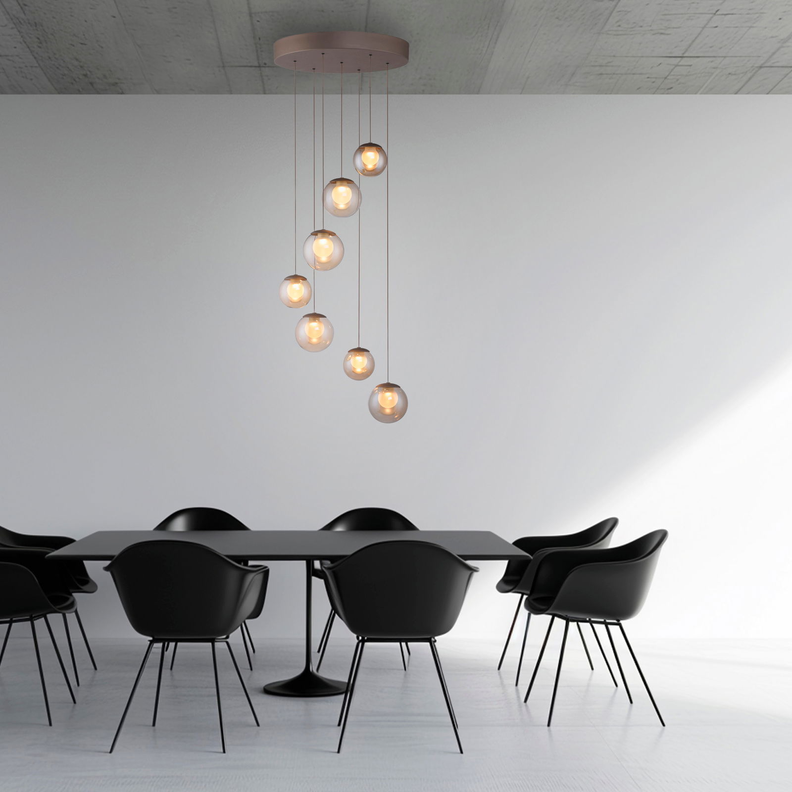 Moderne LED-Pendelleuchte mit sieben kugelförmigen Lampen, die in einer spiralförmigen Anordnung von der Decke hängen, über einem eleganten Esstisch mit schwarzen Stühlen. Perspektive: Seitenansicht.