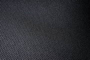 Nahaufnahme eines schwarzen, strukturierten Stoffes, vermutlich Sitzfläche eines Drehstuhls.