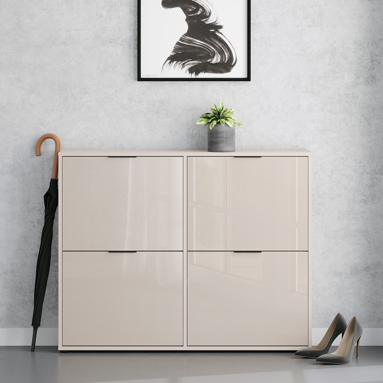 Beiges, hochglänzendes Schuhschrank-/Sideboard mit vier Klapptüren in Frontansicht, vor grauer Wand; oben steht ein kleiner Blumentopf, daneben ein Regenschirm und rechts ein Paar Pumps.