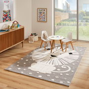 Kinderzimmer mit einem Merinos Kinderteppich LÖWENHERZ, der einen stilisierten Löwen in Grau- und Weißtönen zeigt, umgeben von einem Tisch und zwei Stühlen, mit Blick auf einen sonnigen Garten durch eine große Fensterfront.