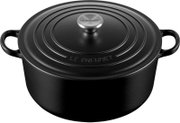 Zwarte ronde Le Creuset braadpan met deksel, twee handgrepen en zilverkleurige knop, schuin van voren en bovenaf gezien