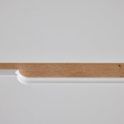 Detailfoto van een ladekast met een wit oppervlak en een houten rand.