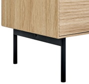 Detailaufnahme eines Möbelstücks aus hellem Holz mit schwarzem Metallgestell, Ansicht schräg von vorne unten auf die Ecke
