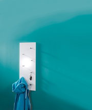 Weiße Wandgarderobe mit mehreren Haken, an der ein blauer Hoodie und ein Schlüsselbund hängen, vor einer türkisfarbenen Wand. Perspektive von vorne.