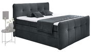 Boxspringbett in dunklem Stoffbezug mit Kopf- und Fußteil, seitliche Perspektive