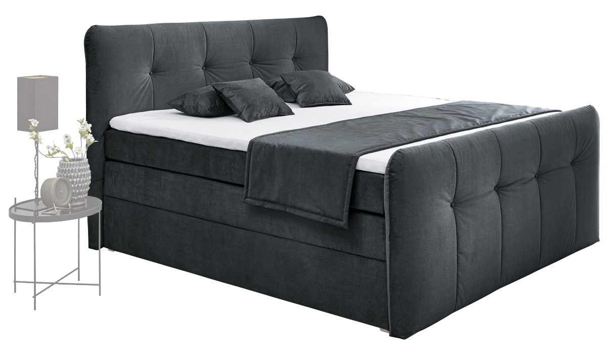 Boxspringbett in dunklem Stoffbezug mit Kopf- und Fußteil, seitliche Perspektive
