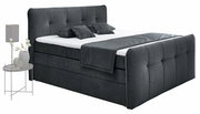Boxspringbett in dunklem Stoffbezug mit Kopf- und Fußteil, seitliche Perspektive