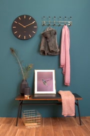 Garderobe gold XL an einer blauen Wand, frontal fotografiert, mit Jacken und Schal behängt, daneben eine Uhr und Dekoration auf einer Bank.