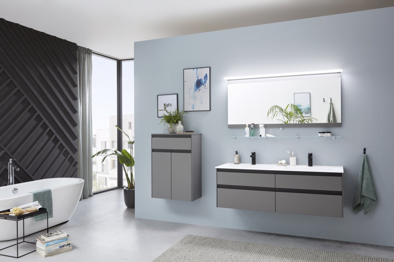 Moderne Badkombination mit grauen Schränken, Doppelwaschbecken und großem Spiegel, seitliche Perspektive