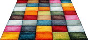 Bunter Teppich mit quadratischem Patchwork-Muster in Rot, Blau, Gelb, Orange, Grün und Pink, in schräger Perspektive von oben fotografiert