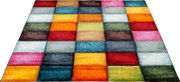 Bunter Teppich mit quadratischem Patchwork-Muster in Rot, Blau, Gelb, Orange, Grün und Pink, in schräger Perspektive von oben fotografiert