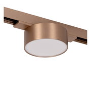 Runde LED-Deckenspot-Leuchte in gebürstetem Kupferton an einer Stromschiene mit opalem Diffusor, Ansicht schräg von unten