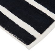 Nahaufnahme eines gestreiften Gästetuchs in Schwarz und Weiß, perspektivisch von der Ecke aufgenommen.