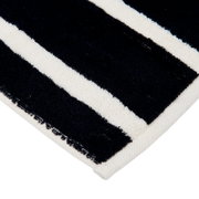 Close-up van een gestreepte gastendoek in zwart en wit, vanuit de hoek gefotografeerd.