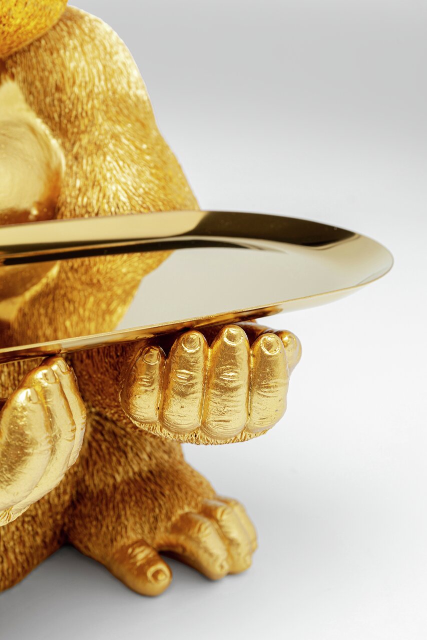Nahaufnahme einer goldenen Deko-Figur eines Gorillas, der ein Tablett hält, aus der Perspektive von vorne.