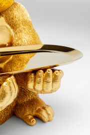 Nahaufnahme einer goldenen Deko-Figur eines Gorillas, der ein Tablett hält, aus der Perspektive von vorne.