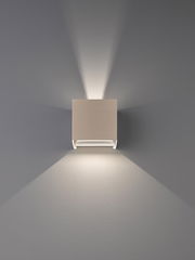 Moderne, quadratische Wandleuchte in Weiß mit Up-&-Down-Light, frontal von vorn an der Wand fotografiert, wirft symmetrische Lichtkegel nach oben und unten.