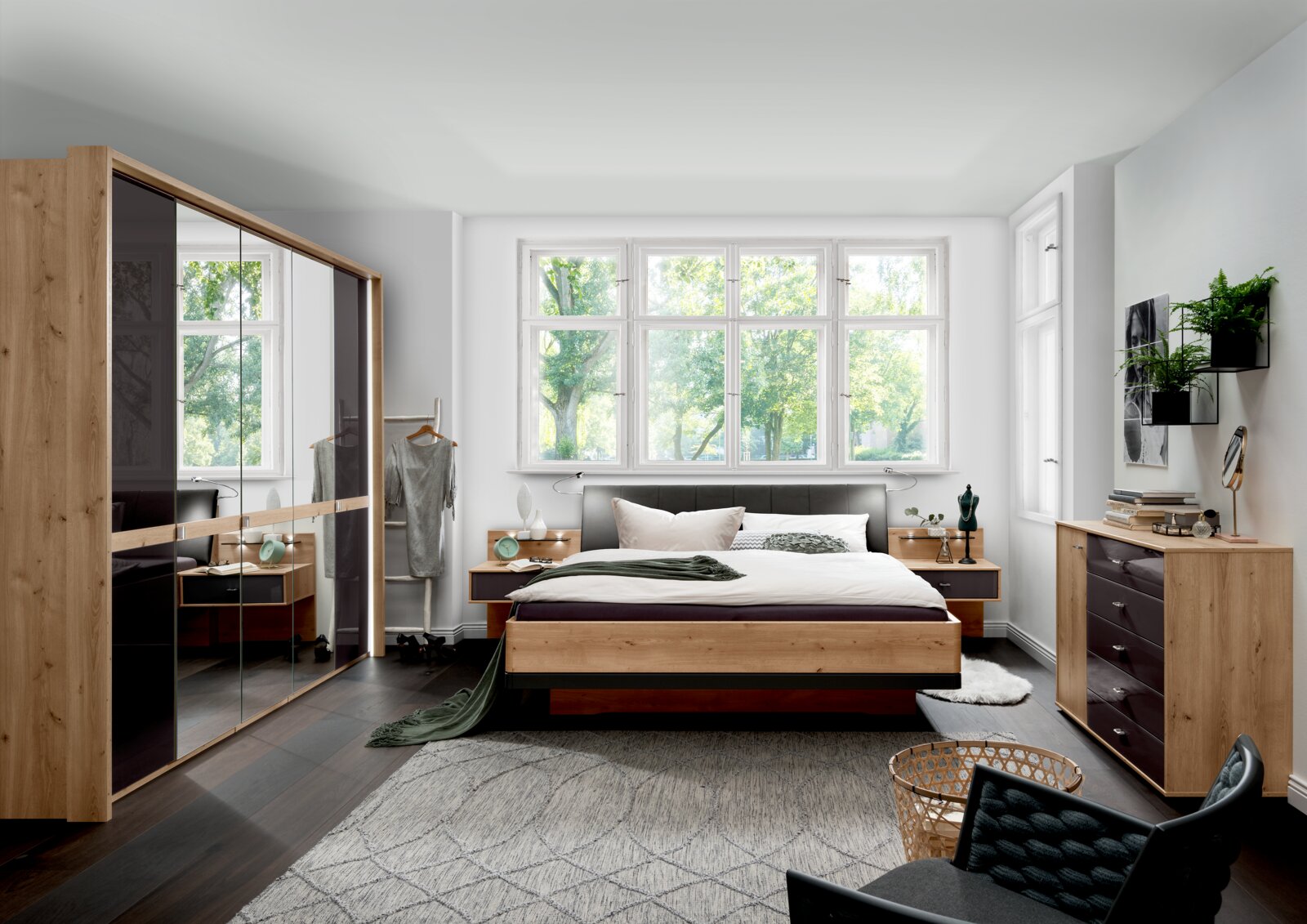 Moderne slaapkamer met een houten futonbed, omringd door stijlvolle meubels en grote ramen die uitzicht bieden op de groene omgeving. Aanzicht van voren op het bed.