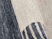 Nahaufnahme eines Frisé-Teppichs mit grauen und cremefarbenen Streifen, seitliche Perspektive