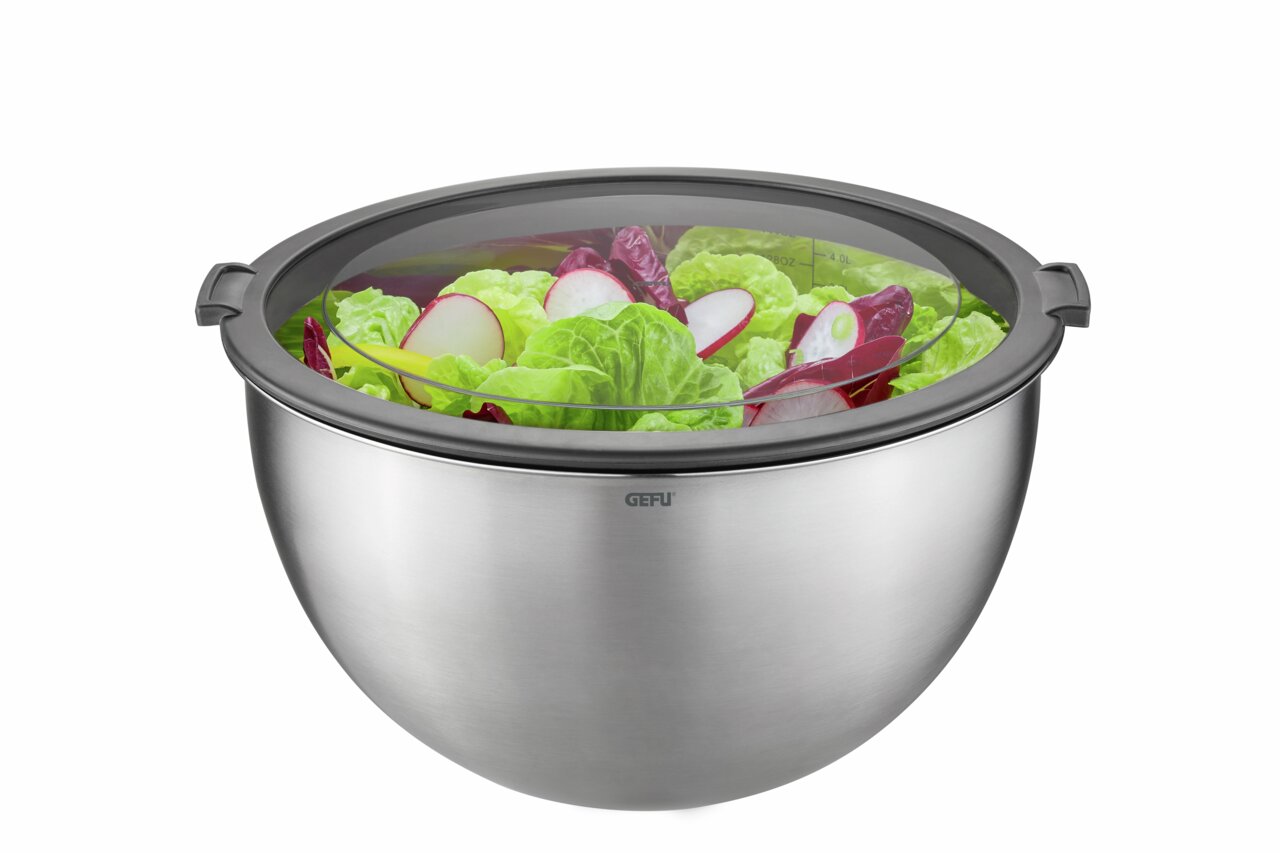 Edelstahl-Schüssel mit transparentem Deckel, gefüllt mit frischem Salat, aus seitlicher Perspektive