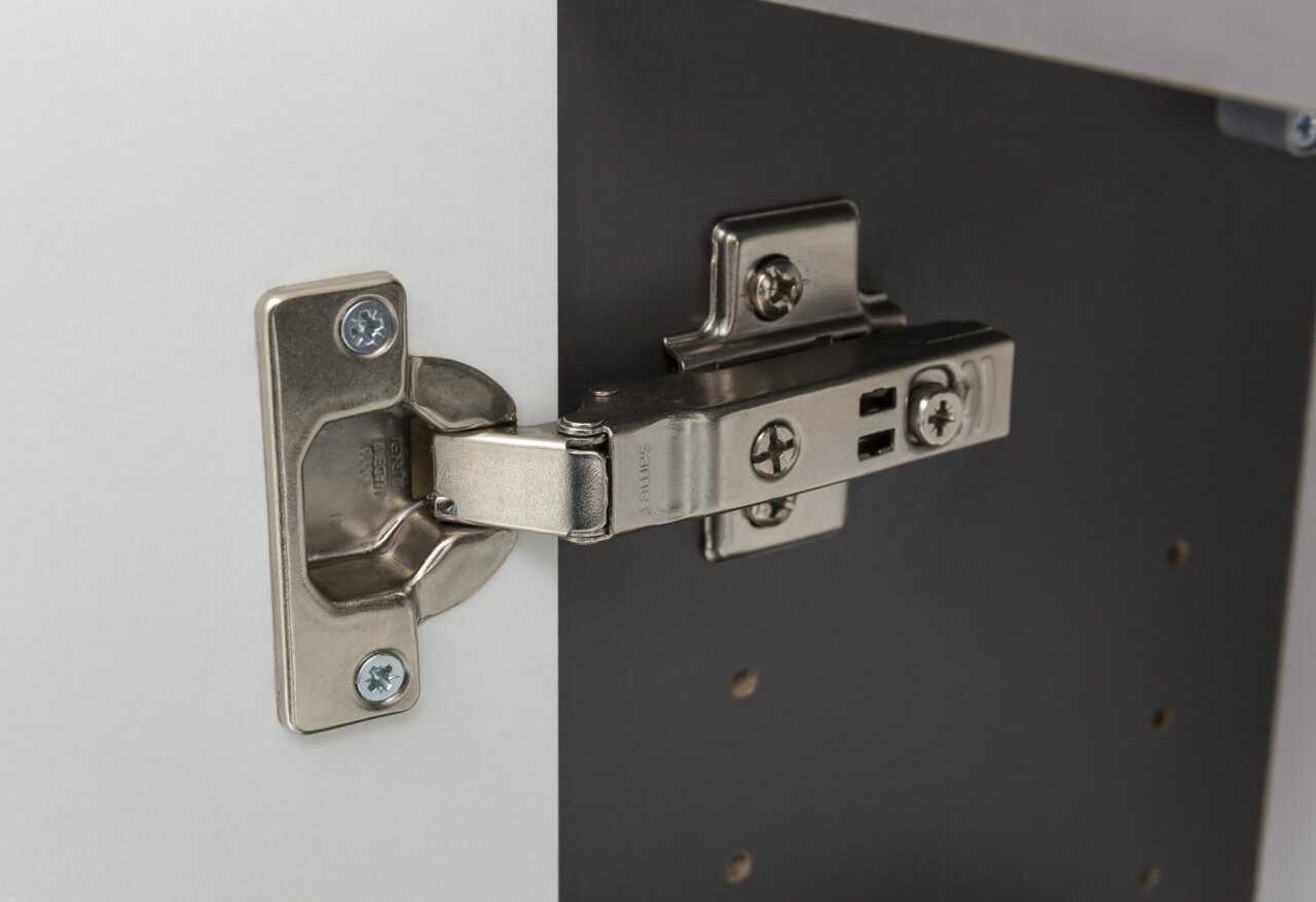 Nahaufnahme eines Metallscharniers an einem Hochschrank, seitliche Perspektive
