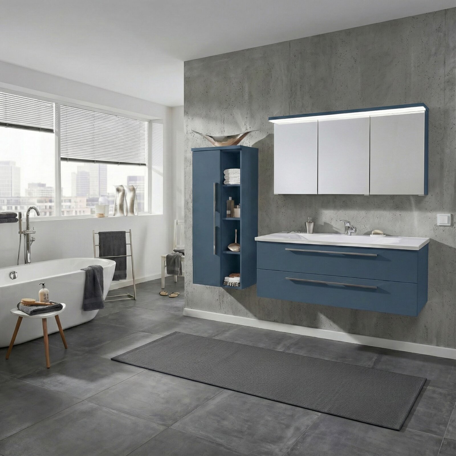 Dieter Knoll Waschtisch-Set AVIANO Modernes Badezimmer mit blauem Waschtischunterschrank und weißem Spiegelschrank mit LED-Beleuchtung an Betonoptik-Wand, seitliche Perspektive schräg von vorn