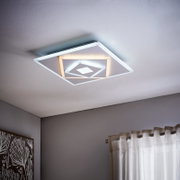 Moderne LED-plafondlamp in vierkante vorm, gezien van onderaf, met een geometrisch ontwerp en warmwitte verlichting.
