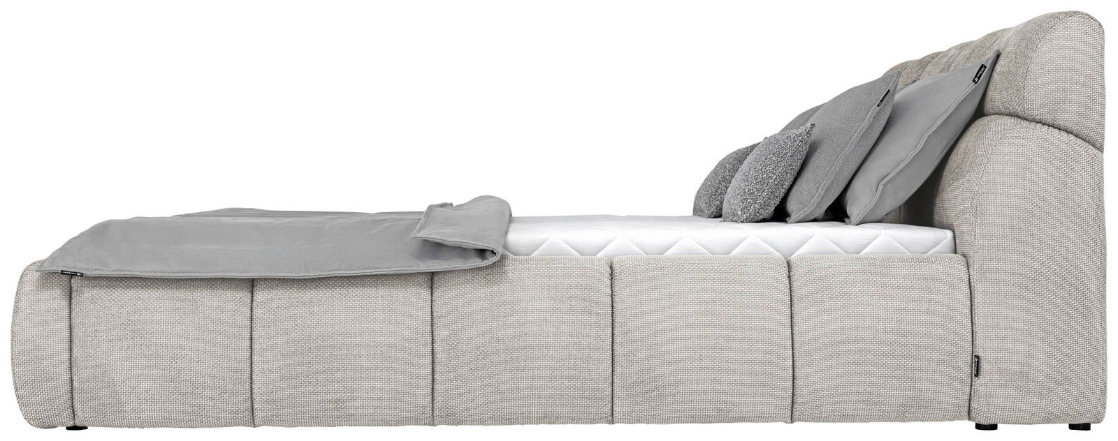 Seitenansicht eines grauen Polsterbetts mit Kissen und Decke